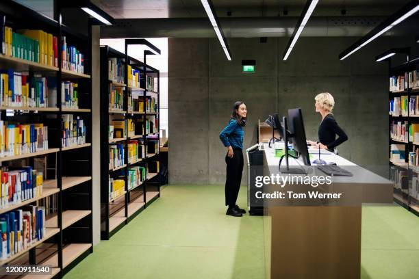 student talking to librarian in modern library - bibliotecário imagens e fotografias de stock