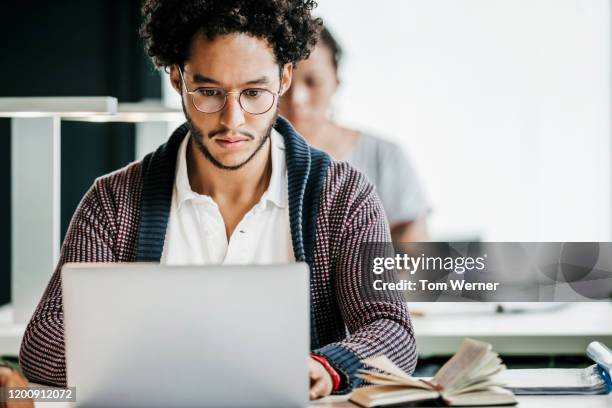 student concentrating on studies in library - adult reading stock pictures, royalty-free photos & images