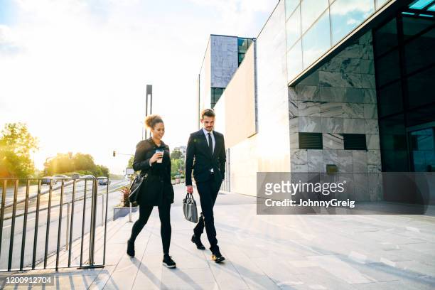 business associates arriving to work in morning - office building entrance people stock pictures, royalty-free photos & images
