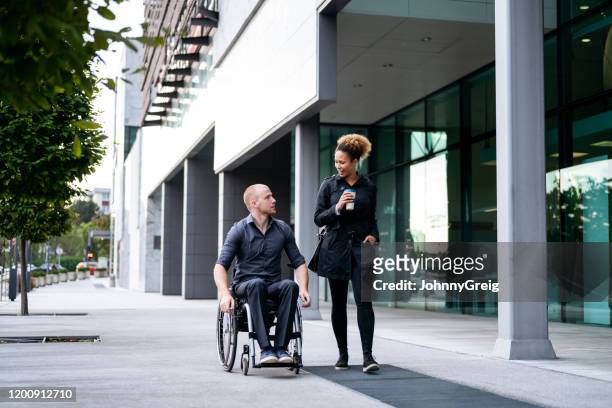 young male and female business colleagues arriving for work - wheelchair stock pictures, royalty-free photos & images