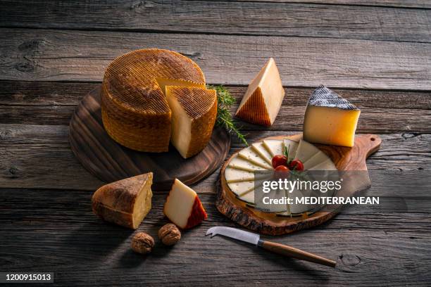 queso manchego de españa sobre mesa de madera - queso manchego fotografías e imágenes de stock