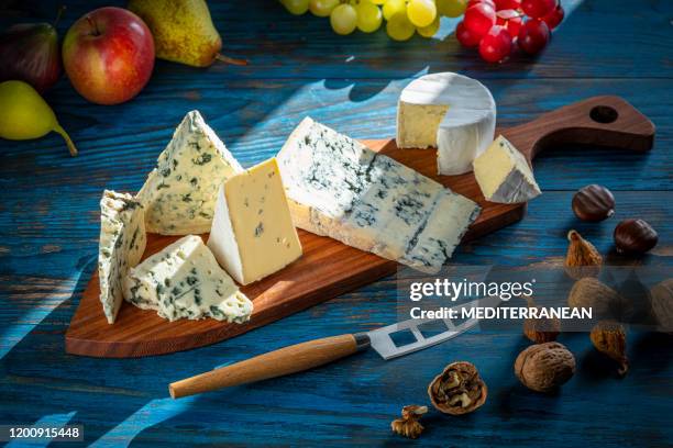 blue cheese cutting board with knife on blue - roquefort cheese stock pictures, royalty-free photos & images