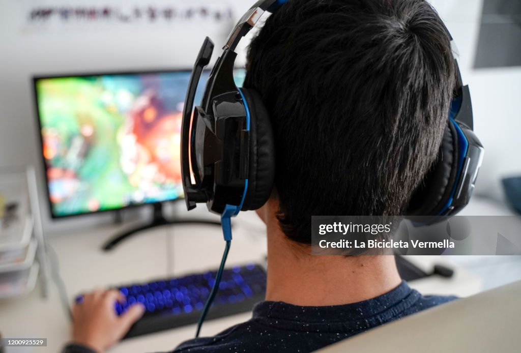 Boy with headphones playing on his computer