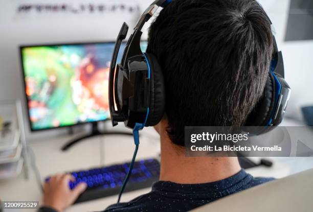 boy with headphones playing on his computer - computer gaming stock pictures, royalty-free photos & images