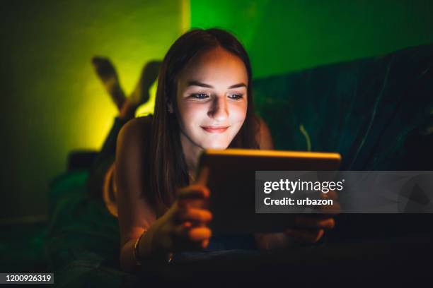 woman watching movie on tablet - living room night dark stock pictures, royalty-free photos & images