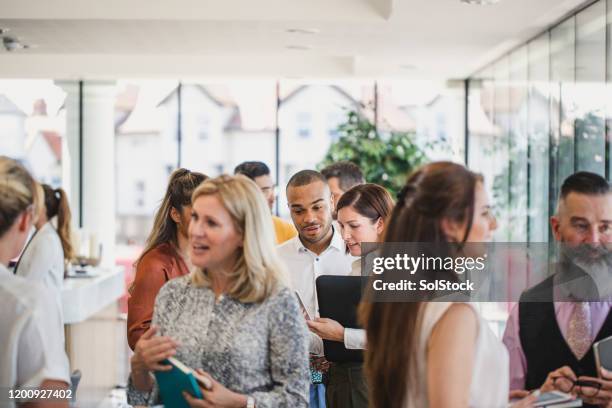 work colleagues meeting and talking in corporate building - conference event stock pictures, royalty-free photos & images