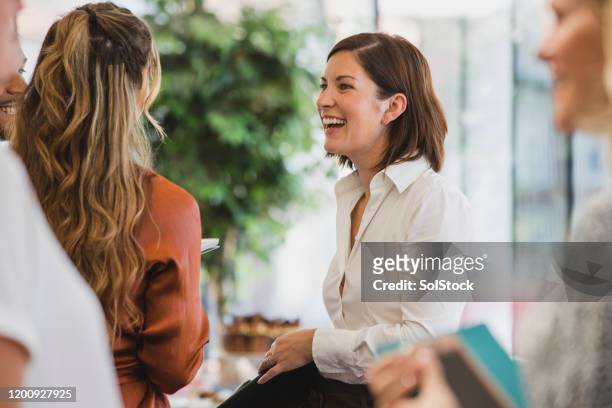 fröhliche kollegen lachen bei firmenveranstaltung - partnership teamwork stock-fotos und bilder
