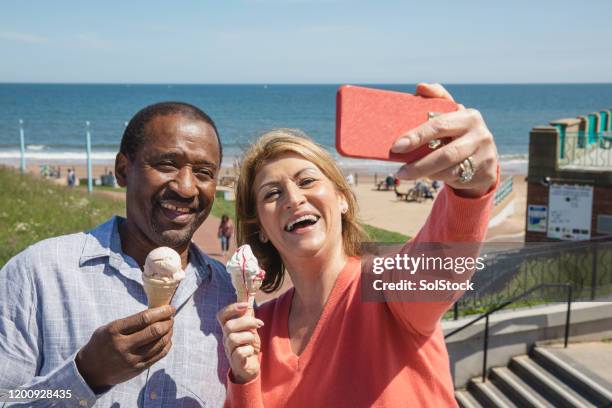 fröhliche multi ethnische senior paar selfie am meer - eisstockschießen stock-fotos und bilder