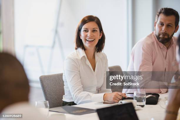 cheerful woman in business meeting with colleagues - managing director office stock pictures, royalty-free photos & images