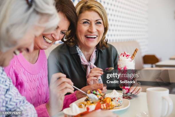 mujeres alegres de la tercera edad riendo juntos en la heladería - ice cream sundae fotografías e imágenes de stock