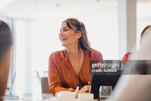 cheerful businesswoman laughing at conference table - portrait concentration stock pictures, royalty-free photos & images