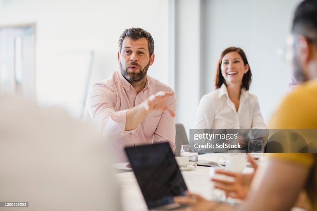 Affärsman med skägg som förklarar i mötet med kollegor