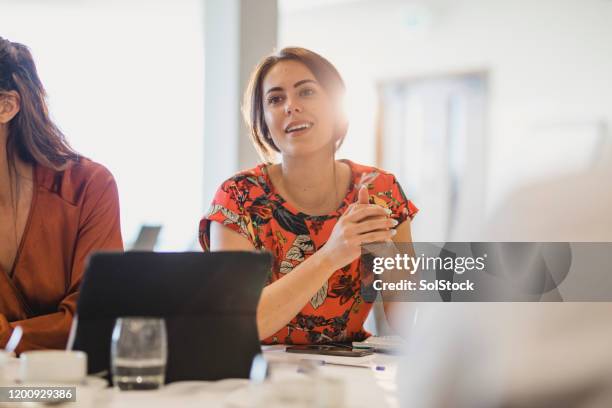 joven empresaria confiada escuchando atentamente en la mesa de la conferencia - candidat fotografías e imágenes de stock