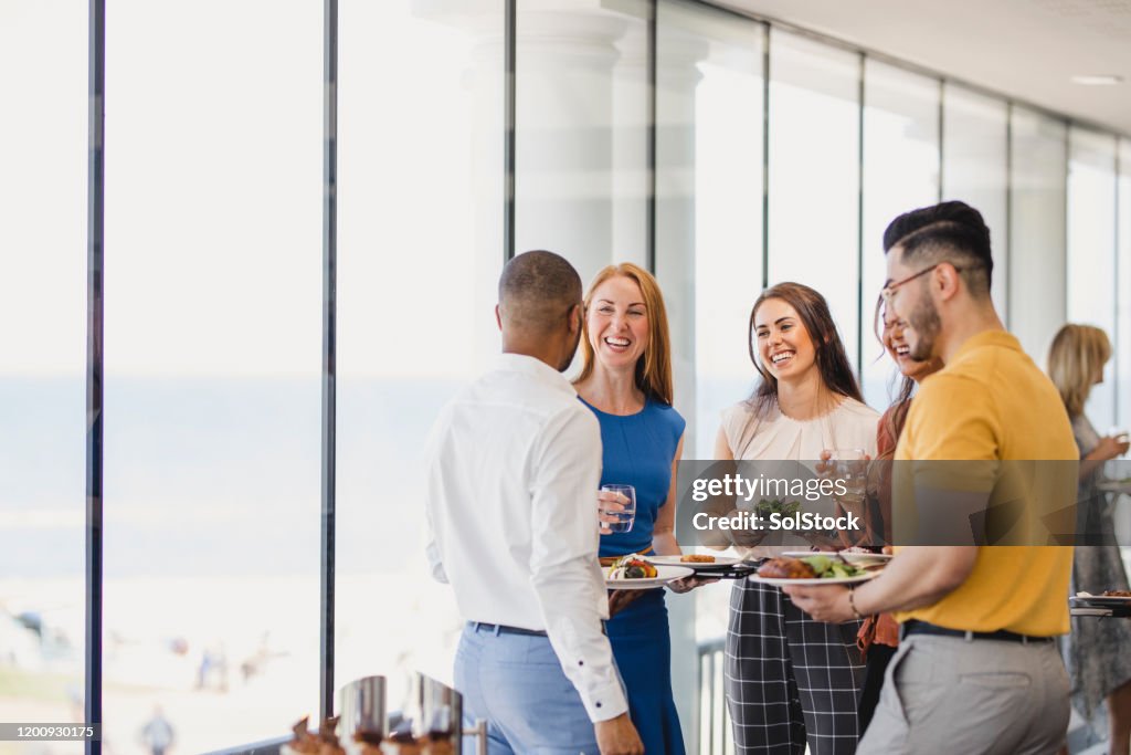 Groep vrolijke collega's die van lunchonderbreking bij gebeurtenis genieten