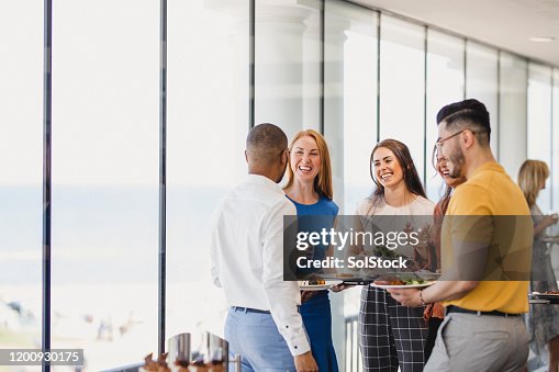 Group of cheerful colleagues enjoying lunch break at event Group of cheerful colleagues enjoying lunch break at event