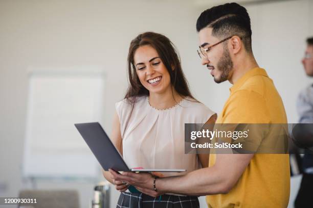 hipster giovane uomo usando laptop con allegra collega donna - coworker foto e immagini stock