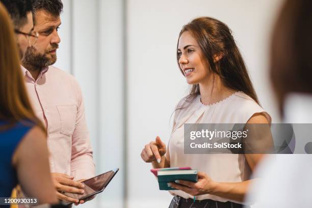 joven empresaria confiada en el trabajo en red con colegas - organizador de eventos fotografías e imágenes de stock