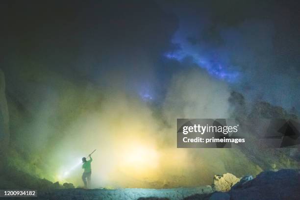 sulfur lake and smoking mine mountain  in the morning at kawah ijen volcano east java indonesia - acid warning stock pictures, royalty-free photos & images