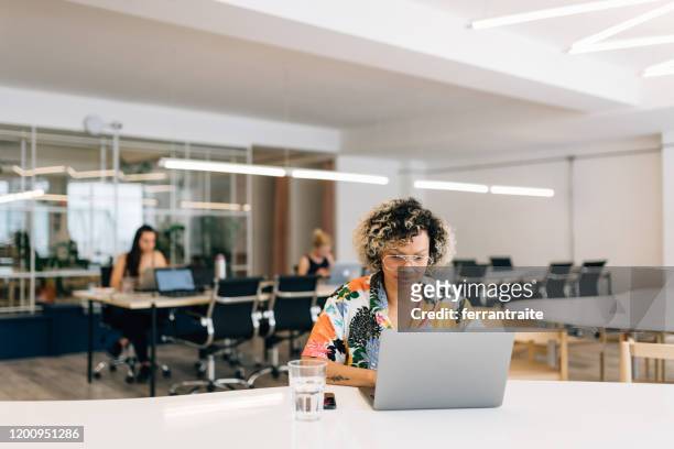 freelance businesswoman working in coworking office - hot desking stock pictures, royalty-free photos & images