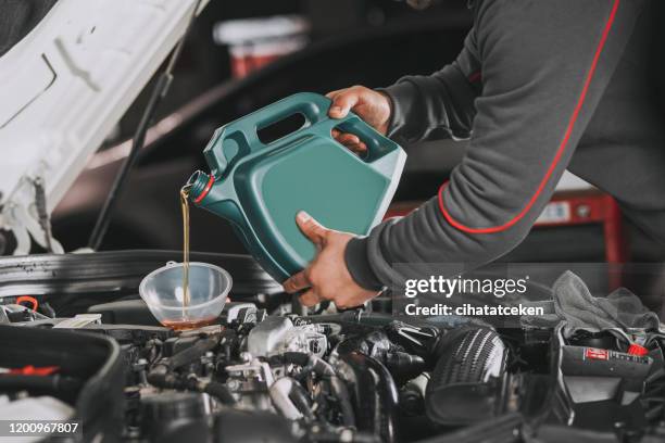 vertiendo aceite en el motor del coche. - oil change fotografías e imágenes de stock