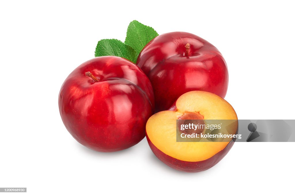 Fresh red plum and half with leaves isolated on white background