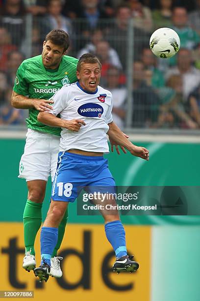 Sokratis Papastathopoulos of Bremen and Bastian Heidenfelder of Heidenheim go up for a headerduring the first round DFB Cup match between 1. FC...