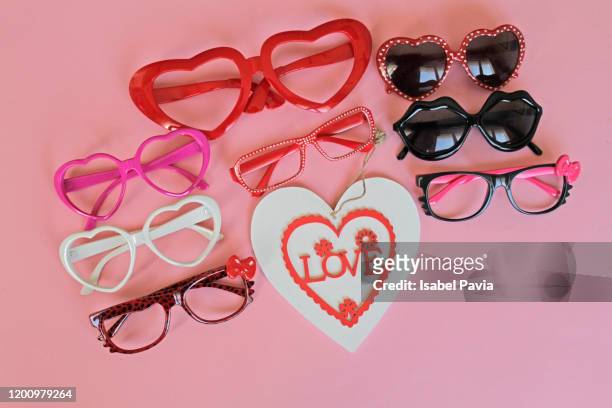 eyeglasses and love heart on pink background - positivism stockfoto's en -beelden