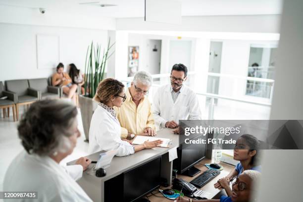 senior men arriving at hospital - medical lobby stock pictures, royalty-free photos & images