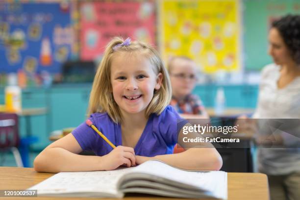 portrait of a 1st grade girl in the classroom - english language stock pictures, royalty-free photos & images