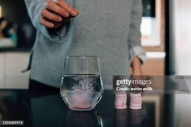 effervescent tablets in water on the table - effervescent tablet stock pictures, royalty-free photos & images