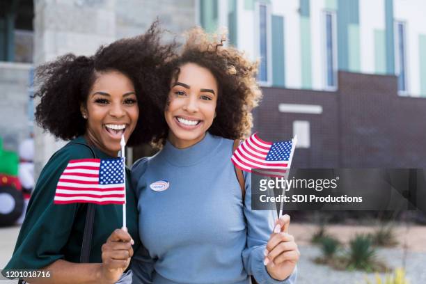 兩位女性朋友在投票後揮舞旗幟，微笑 - votes for women 個照片及圖片檔