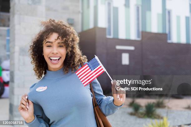 a mulher adulta meados de indica a etiqueta "eu votei" e a bandeira americana - american influencer - fotografias e filmes do acervo