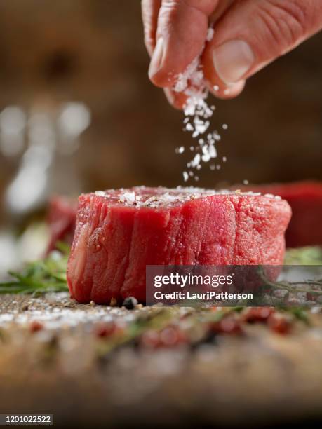 seasoning raw fillet mignon steaks - filet mignon stock pictures, royalty-free photos & images