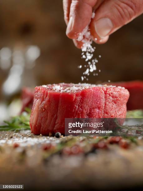 seasoning raw fillet mignon steaks - sprinkling imagens e fotografias de stock