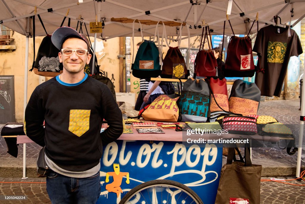 Local artist working in small outdoors market in Bologna, Italy.