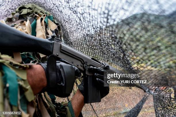 Militia snipper armed with a 7.62mm caliber FAL rifle covered with a black net takes part in military exercises for the 'Bolivarian Shield 2020...