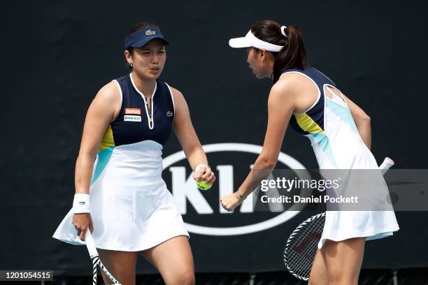 Hao-Ching Chan and Latisha Chan of Taiwan talk tactics during their Women's Doubles first round match against Oksana Kalashnikova of Georgia and Miyu...