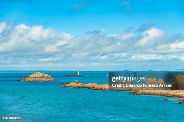 view of the ocean / sea, the coastal features, the turquoise water and rocks at pointe du grouin on the coast of bretagne against a sunny clear blue sky - cancale bildbanksfoton och bilder