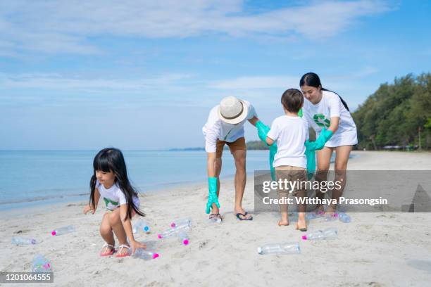 young happy parents having rubber gloves collecting rubbish - pick rubbish stock-fotos und bilder