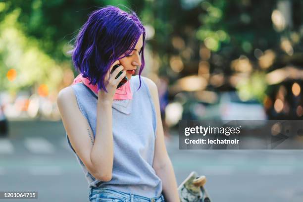 het meisje dat van de schaatser aan de telefoon in de straat in buenos aires spreekt - purple hair stockfoto's en -beelden