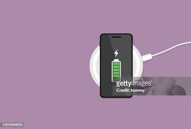 illustrazioni stock, clip art, cartoni animati e icone di tendenza di il telefono cellulare ha una batteria completa su un caricabatterie wireless - tecnologia mobile