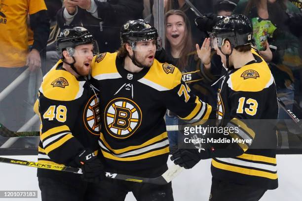 Jake DeBrusk of the Boston Bruins celebrates with Matt Grzelcyk and Charlie Coyle after scoring a goal against the Vegas Golden Knights during the...