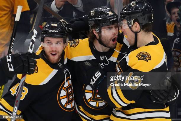 Jake DeBrusk of the Boston Bruins celebrates with Matt Grzelcyk and Charlie Coyle after scoring a goal against the Vegas Golden Knights during the...