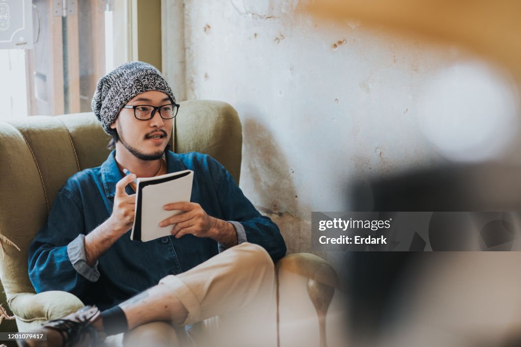 Lifestyles von Hipster-Männern beim Nachdenken über die Ideen seiner Arbeit im rustikalen Café