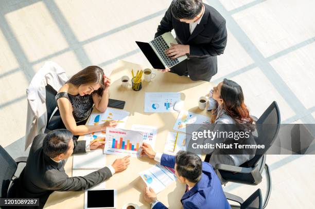 asian business people brainstomming with laptop and some printed business information in the meeting room. - market research stock pictures, royalty-free photos & images