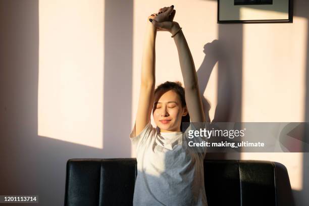 a chinese beauty stretches on the sofa - self improvement stock pictures, royalty-free photos & images