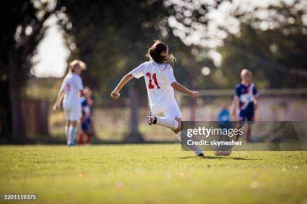 試合でボールを蹴る決定された女子サッカー選手の背面図。 - スポーツ　若者 ストックフォトと画像