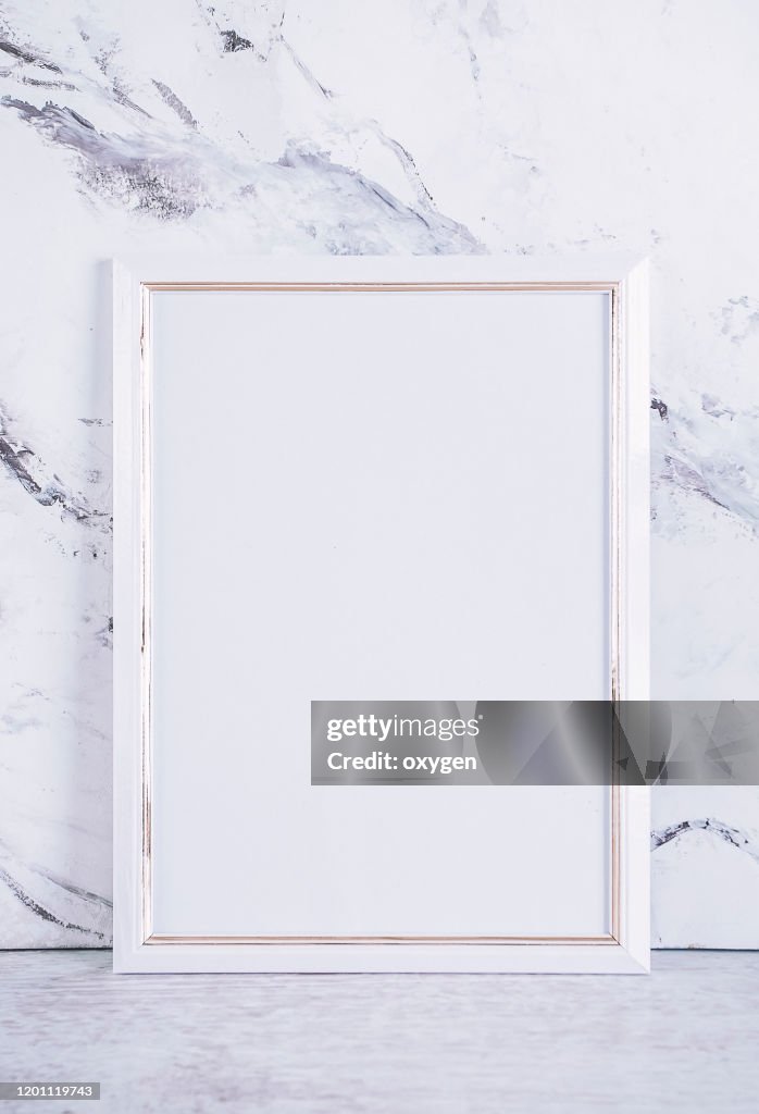 Blank White Picture Paper Frame Poster on Gray Marble table at concrete wall, Template mock up for adding your design Baclground