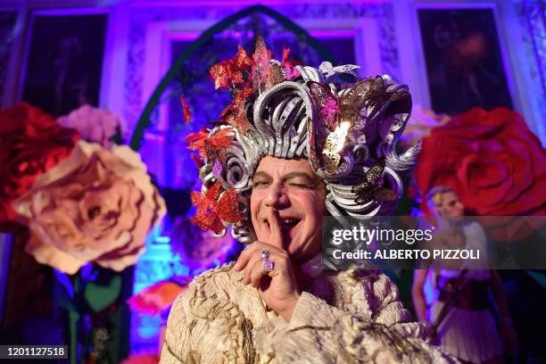 Reveller wearing a mask and a period costume gestures during a masked ball at a dinner in Ca' Vendramin Calergi Palace during the Venice Carnival on...