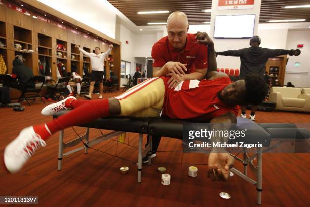 Chiropractor Tomo Harada of the San Francisco 49ers adjust Jaquiski Tartt in the locker room prior to the game against the Green Bay Packers at...